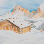 Verschneite Berghütte mit Bergspitzen im Abendrot